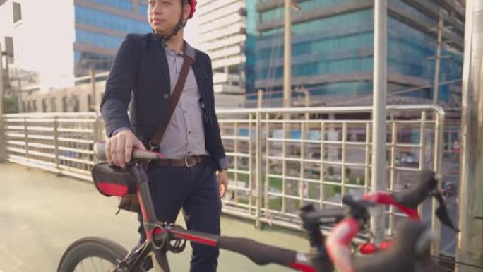 年轻有魅力的快乐商人早早完成工作后，愉快地推着自行车，在回家的路上，使用立交桥减少道路事故，城市日常