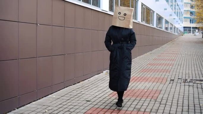 微笑快乐的纸袋脸走在街上。