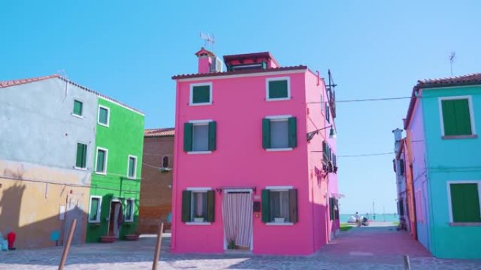 布拉诺 (Burano) 的无男子的街道，在阳光下拥有整洁的粉红色房屋