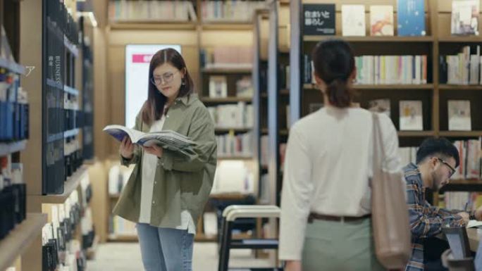 图书馆的MLS年轻学生正在阅读教科书