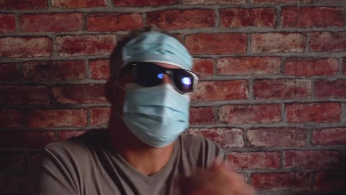 墙壁背景上的成年男子。脸上戴着墨镜和医用口罩