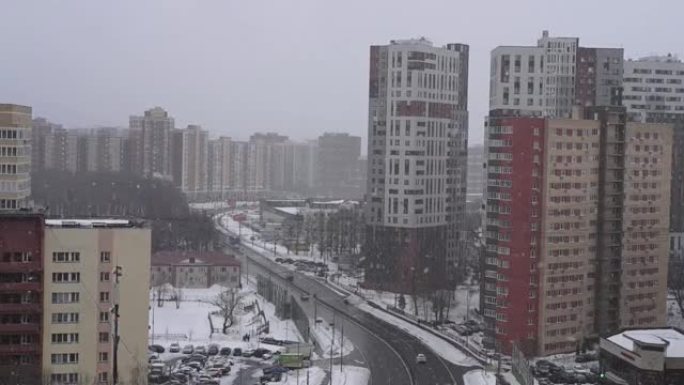 俄罗斯莫斯科，02.28.2021-降雪的冬季城市景观。从高处看城镇。街上有雪花的暴风雪。居民楼和一