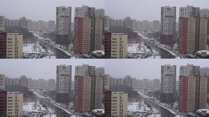 俄罗斯莫斯科，02.28.2021-降雪的冬季城市景观。从高处看城镇。街上有雪花的暴风雪。居民楼和一