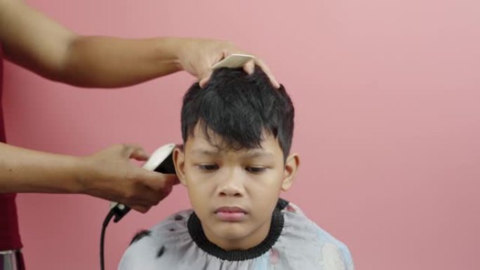 亚洲男孩在家由母亲理发
