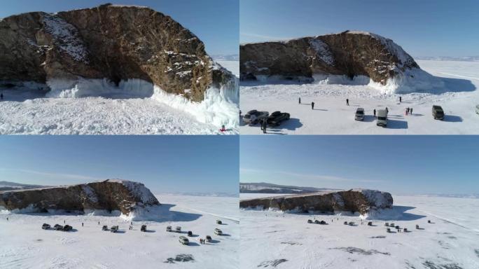 鸟瞰冰冻的贝加尔湖的岩石岛，许多人四处走动。受欢迎的旅游目的地。冬季景观。全景