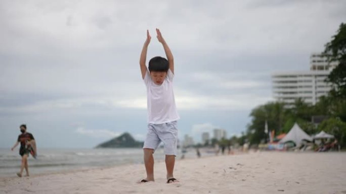 亚洲男孩在海滩上锻炼