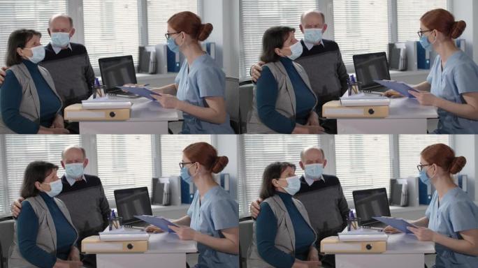 大流行，在医院办公室接受治疗期间，与女主治医师协商，戴着医用口罩防止病毒和感染的老年男女