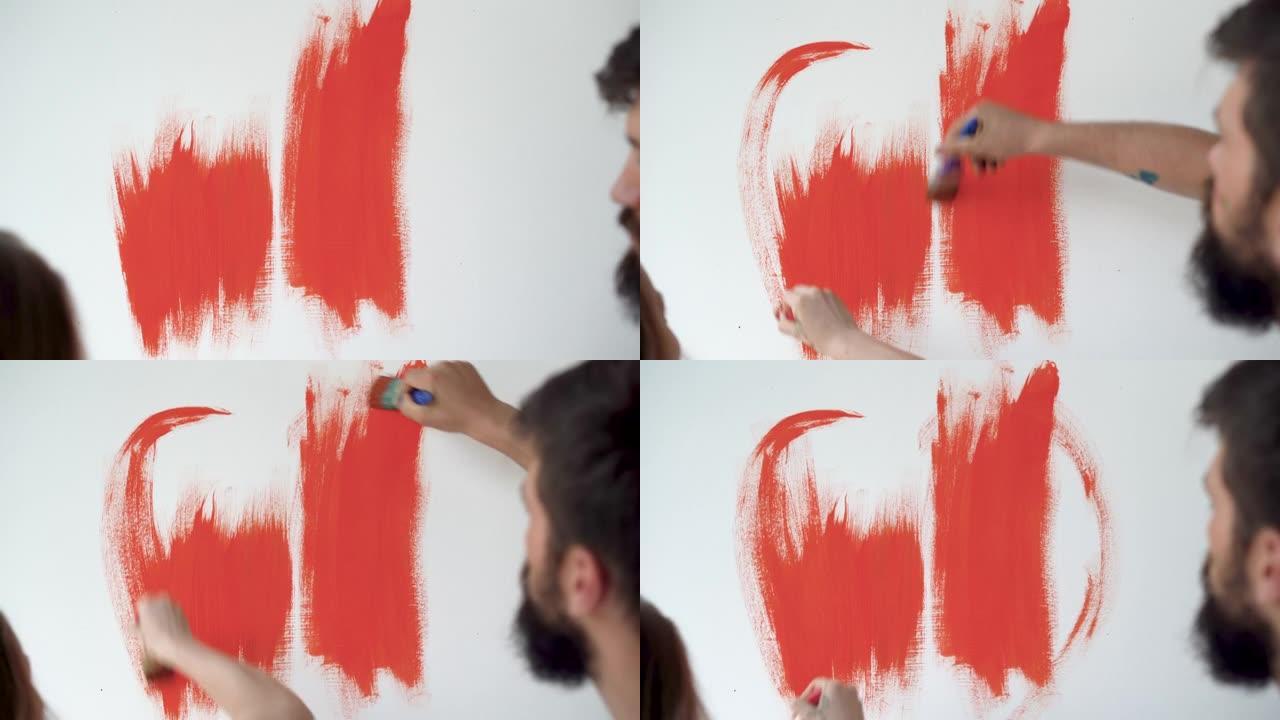 男女手握画笔并将墙壁涂成橙色的特写镜头。我们做自己的家庭装修概念。