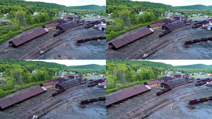 废弃的窄轨煤铁路的鸟瞰图，生锈的料斗和货车以及支撑建筑物开始恢复