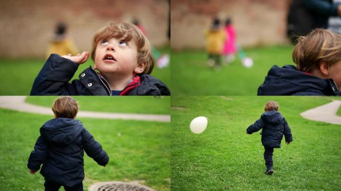 玩气球的孩子。蹒跚学步的孩子在外面玩耍，抓住和踢气球