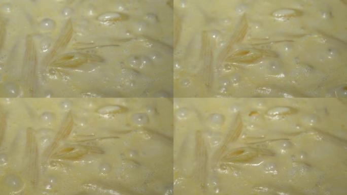 用酱汁和酱汁煮沸的意大利面特写镜头。