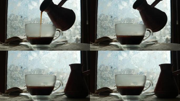 一杯咖啡和一本打开的书在冬天霜冻的窗台上