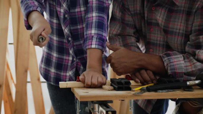 近距离练习木工的学生用年迈的木匠建造物品，家具。培训活动木匠。专业技能提高儿童技能。职业工匠概念
