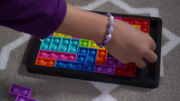 一个小女孩玩橡胶彩虹推流行拼图