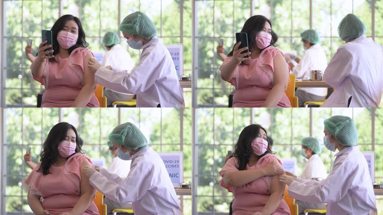 亚洲女性在诊所或医院接种covid疫苗时通过电话自拍的肖像，手持护士注射疫苗以获得免疫力以保护病毒。