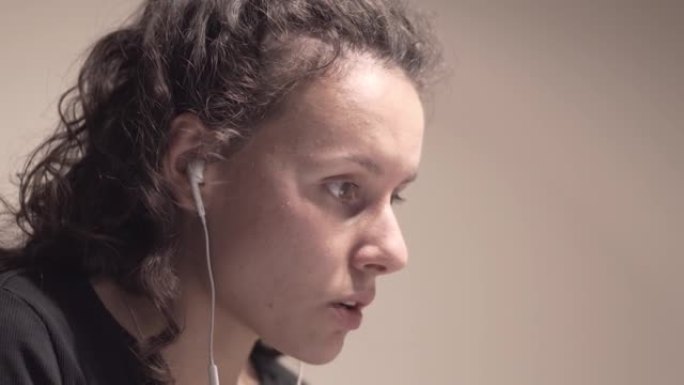 年轻的女商人戴着耳机在笔记本电脑上的视频会议上与队友交谈，在大流行期间远程工作