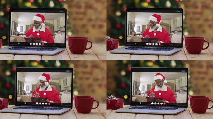 穿着圣诞老人服装的非裔美国人高级男子在笔记本电脑上进行视频通话，并带有圣诞树
