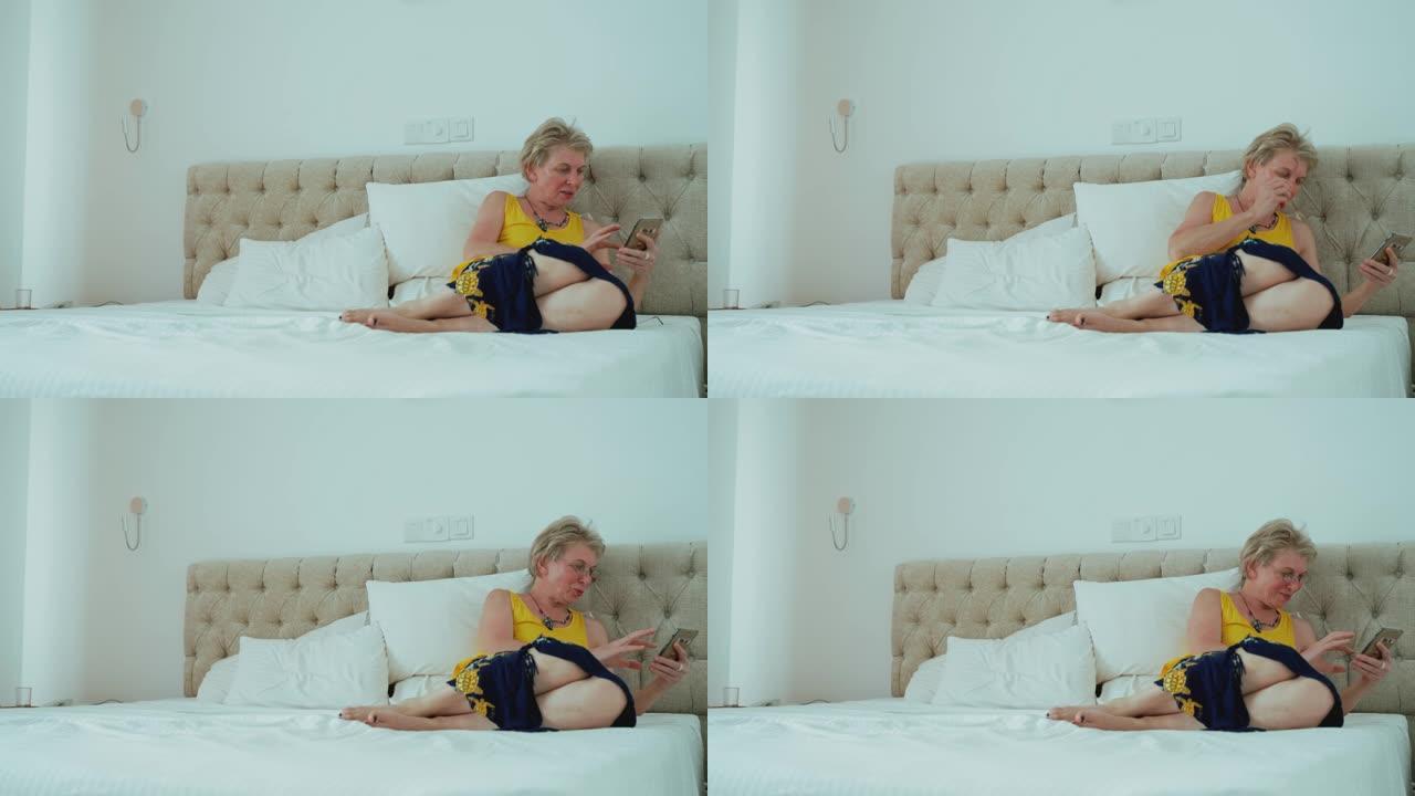 55岁的成熟女性坐在明亮整洁的现代酒店房间的床上时，会用智能手机发短信。