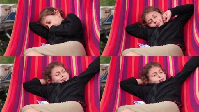昏昏欲睡的小女孩在后院的吊床中醒来