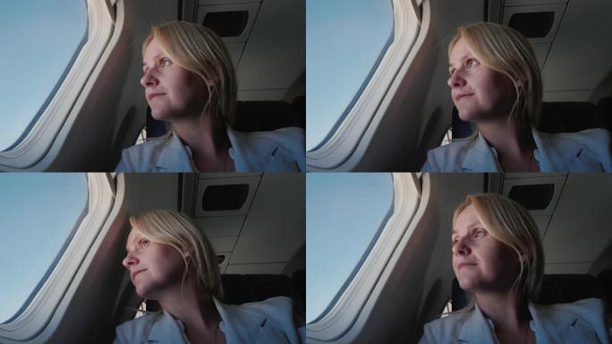 一位自信的女乘客的肖像，在飞机上飞行，看着窗外