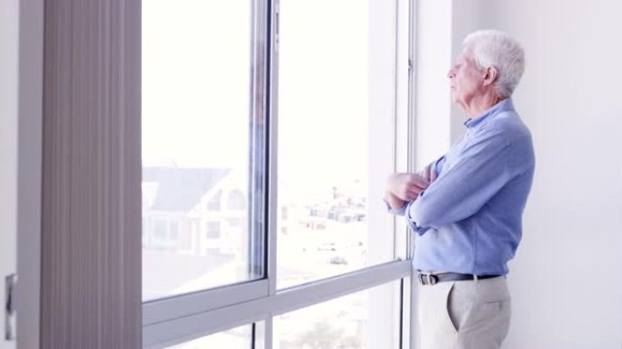 4k视频片段，一名高级男子在家里若有所思地看着窗外