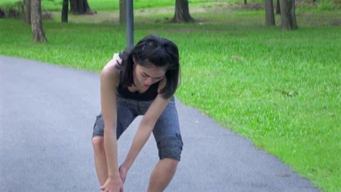 女人在公园跑步，然后脚踝疼痛