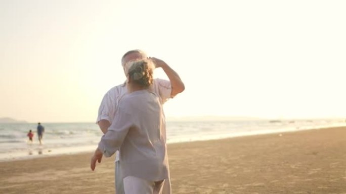 4k亚洲高级夫妇喜欢在夏日日落时在海滩上跳舞和浪漫的假期