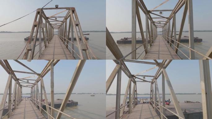日落时分，在恒河河畔渡轮桥上靠着河地平线行走。Achipur在印度加尔各答西孟加拉邦启动Ghat，南