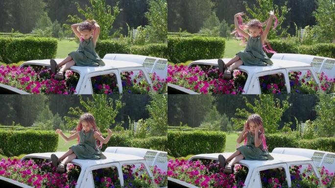 一个穿着粉红色zizi非洲辫子的女孩坐在花装饰车顶上