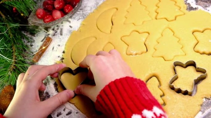 圣诞饼干。制作姜饼饼干的儿童手的特写。家人在家里共度时光。圣诞节和新年概念慢Mo。假日准备概念。节日