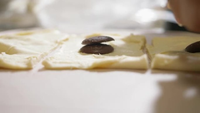 孩子的手在家用巧克力做酥皮面团，生活方式概念。