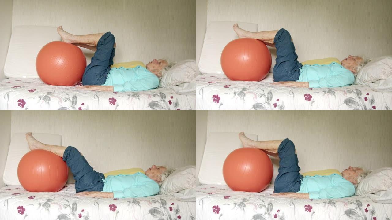 老年白人妇女躺在床上，用健身球进行日常锻炼，以保持健康，灵活和强壮