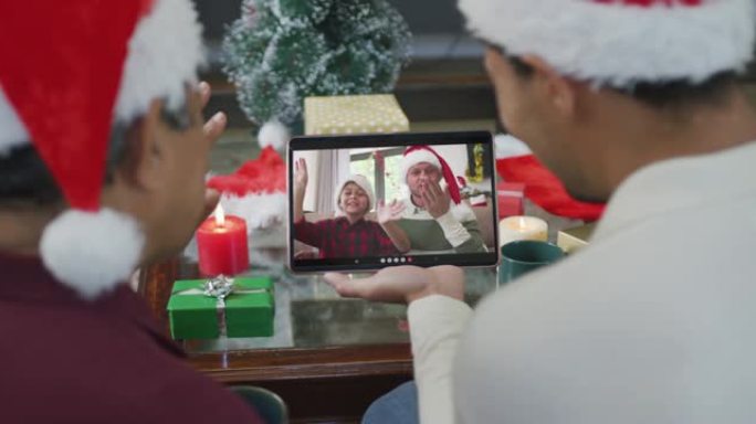 混血儿父子挥舞并使用平板电脑与家人在屏幕上进行圣诞节视频通话