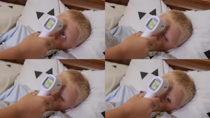 一位母亲用红外温度计测量生病男孩的温度。