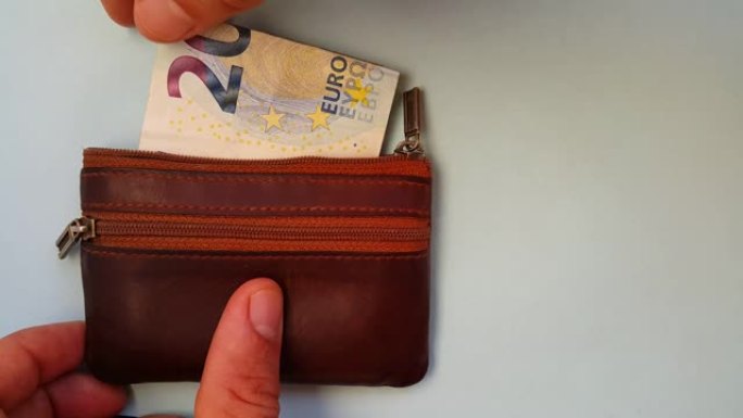 他的手指从钱包里掏出二十欧元。费用和收入。在商店购物。