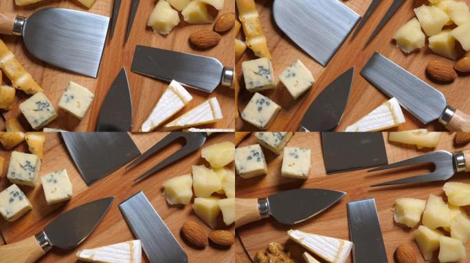 切片奶酪，坚果，葡萄，蜂蜜和小刀放在木盘上。旋转