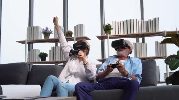 老年成熟夫妇玩虚拟现实眼镜玩得开心，老年夫妇坐在沙发上拿着摇杆边笑边玩电子游戏，快乐老年科技概念