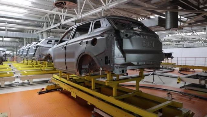 汽车架在工厂喷漆前在地面上，输送机没有人的参与