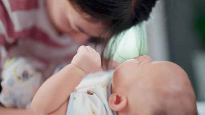 年轻女子在家与婴儿交往的肖像。