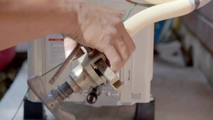 手动关闭-空调技术人员在空调安装过程中使用扩口工具将铜管与火炬连接。