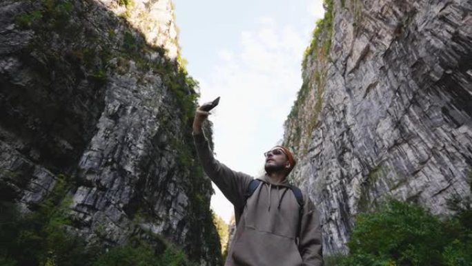 在智能手机摄像头上拍摄。游客在高山上徒步旅行时拍摄山脉。