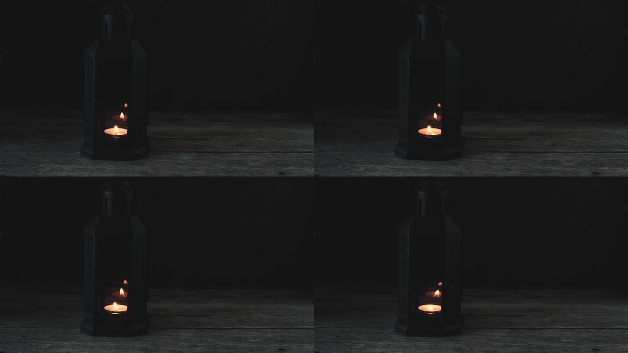老式复古灯，在木桌上的黑暗房间里燃烧着蜡烛。在冷色调中。