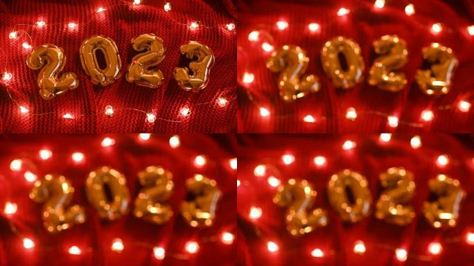 数字2023在一个红色针织舒适的格子和圣诞灯的背景