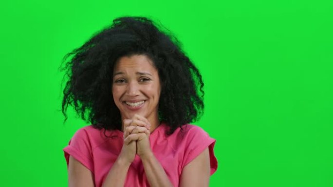 年轻女性非裔美国人保持手掌并索要东西的肖像。卷发的黑人妇女在工作室的绿色屏幕上摆姿势。特写。慢动作就