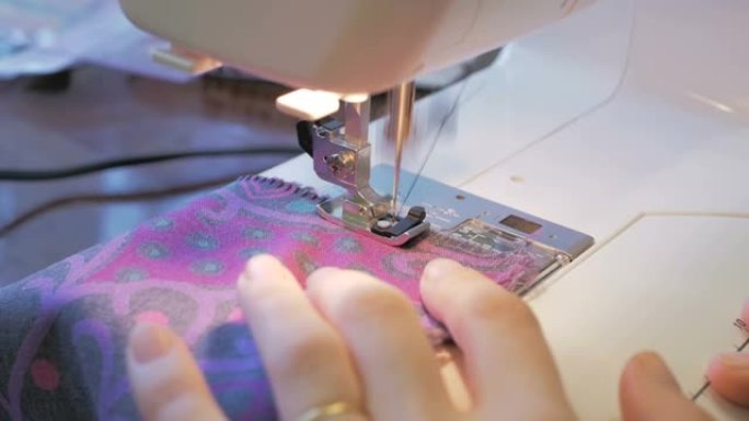 年轻的有爱心的家庭主妇使用缝纫机缝制衣服