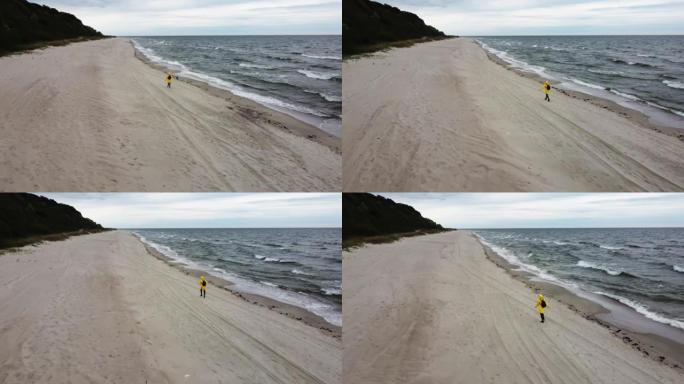 女人在无人机拍摄的风雨如磐的沙滩上奔跑