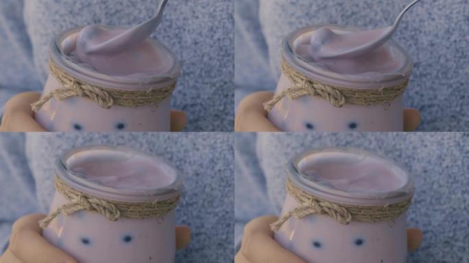蓝莓奶昔配蓝莓。女人吃一杯早餐蛋白质冰沙饮料，该饮料由纯蓝莓，香蕉，牛奶，酸奶和奶酪制成