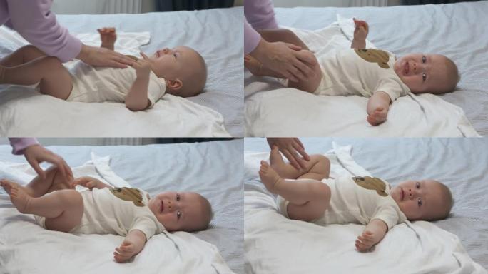 母亲在睡前襁褓婴儿，7个月大的婴儿裹在床上，襁褓有助于防止婴儿挥动胳膊和腿。
