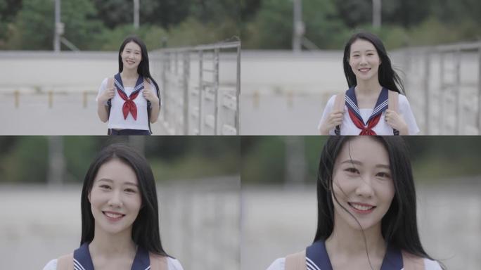 年轻的亚洲女大学生推着自行车微笑