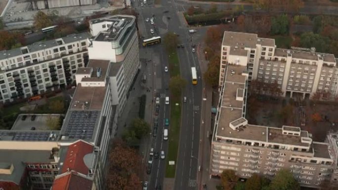 通过城镇的多车道上的公共汽车行驶的前瞻性跟踪。交叉路口交通的高角度视图。德国柏林